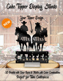 a cake topper with two silhouettes of cowboys on horseback